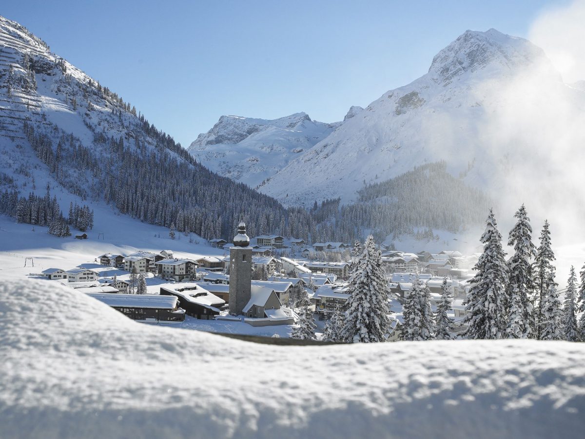 Vila de Lech coberta de neve entre montanhas e pinheiros